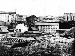 Tekstilfabrikkene Knud Graah og Hjula ligger på vestsiden av Akerselva. I øst er Glads mølle og bygninger som i dag er revet. Muligens er det et teglverk forgunnen. Bildet er trolig fra omkring 1880. Foto: NTM C 10050